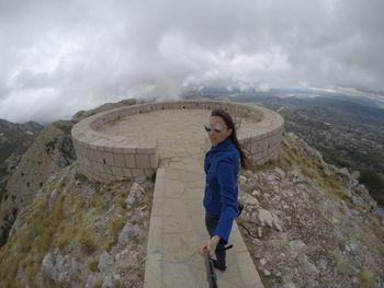 Woman makes a selfie on a background of mountains in montenegro lovcen