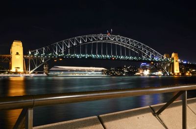 Illuminated sydney harbor bridge against sky at night