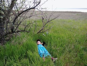 High angle view of girl lying on grassy field