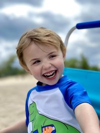 Toddler boy laughing at the beach