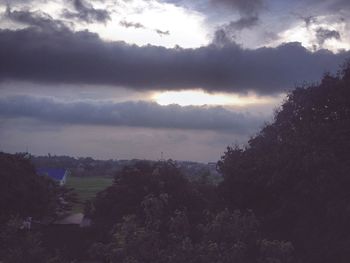 Silhouette of trees against cloudy sky