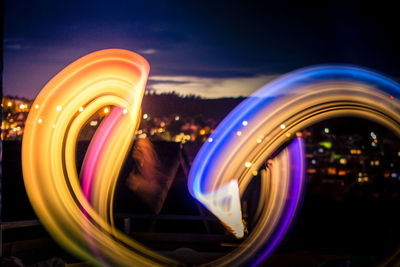 Woman with illuminated light painting in city during night 