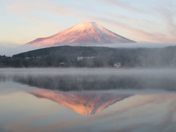 Scenic view of lake and mountain at sunset