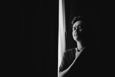 Portrait of young man standing in darkroom