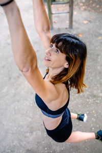 High angle view of woman hanging on monkey bars