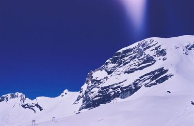 Scenic view of snowcapped mountains against clear blue sky