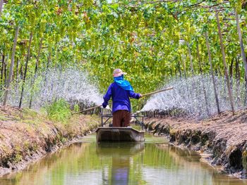 Full length of man holding lake against trees