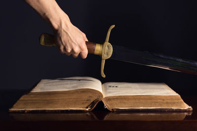 Close-up of hand holding book on table