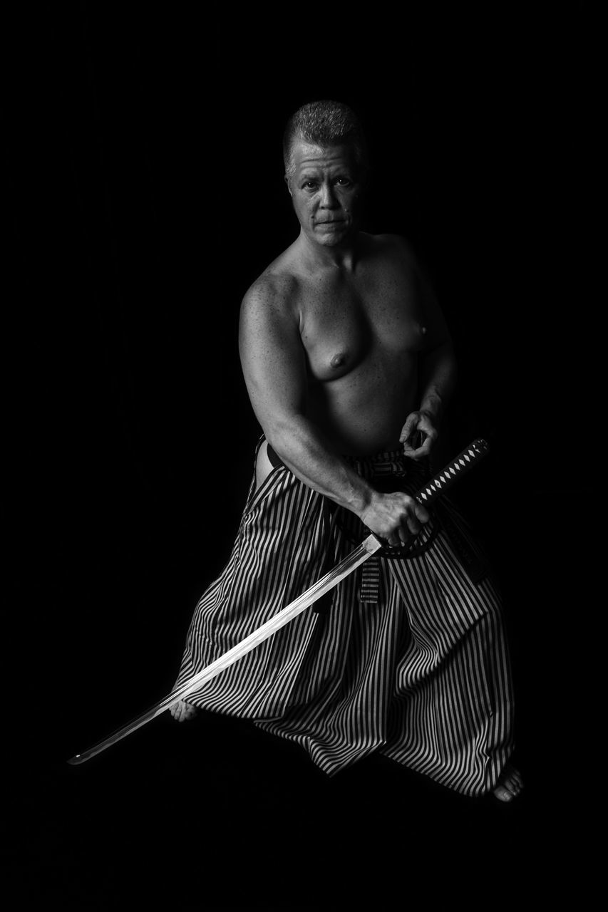 studio shot, human representation, black background, statue, art, sculpture, art and craft, creativity, indoors, copy space, dark, one person, close-up, front view, religion, night, spirituality, low angle view