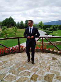 Full length of young man standing against sky