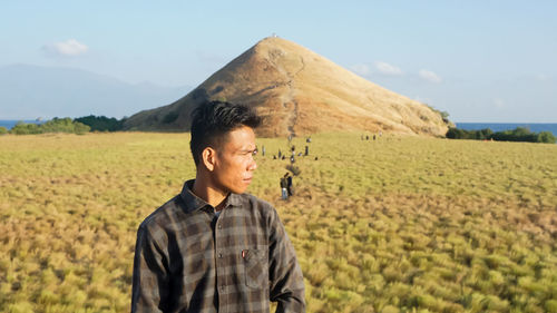 Man standing on field against sky