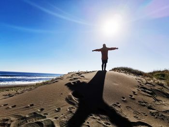 Man standing on sand at beach against sky