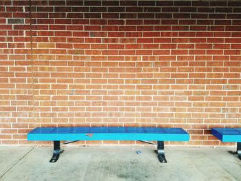 Blue chair against brick wall