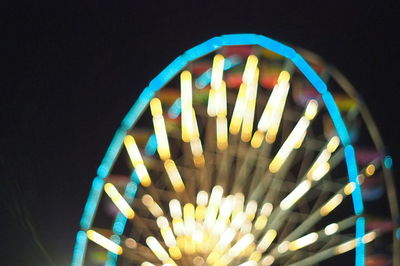 Close-up of illuminated lighting equipment against black background