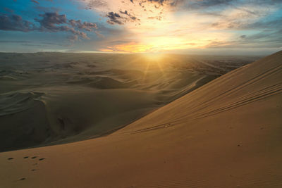 Scenic view of desert against sky during sunset