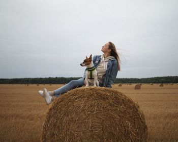 Rear view of woman standing on hay