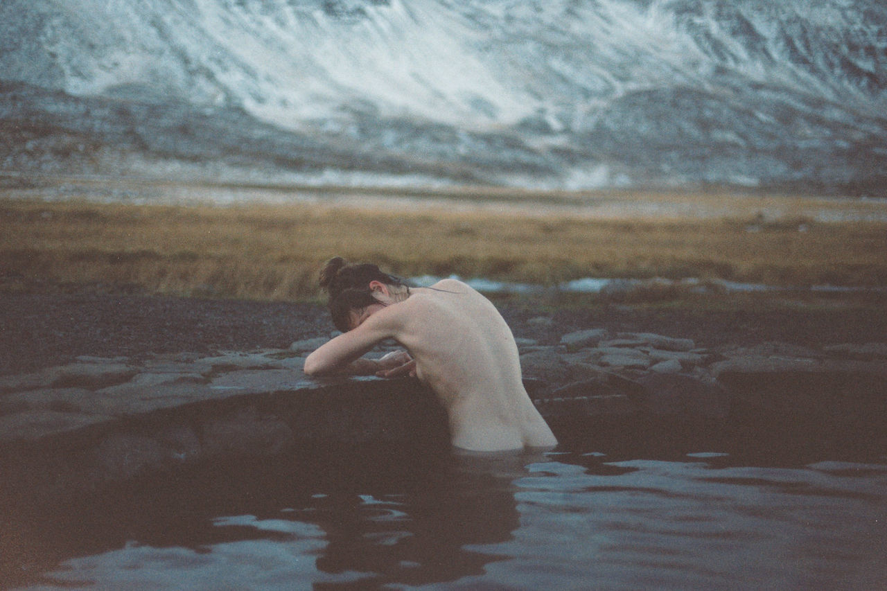 water, one person, real people, mountain, lifestyles, leisure activity, nature, side view, day, waterfront, shirtless, lake, scenics - nature, men, beauty in nature, holiday, mammal, tranquility, outdoors