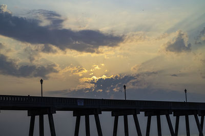 Silhouette bridge over pier against sky during sunset