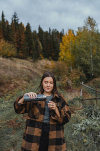 Portrait of smiling young woman standing on land