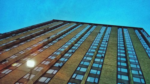 Low angle view of modern building against blue sky