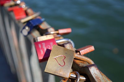 Close-up of love locks on bridge over river