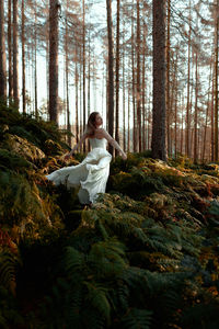 Woman with white dress running in a forest