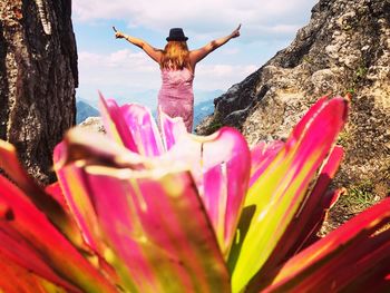 Midsection of woman by pink flowering plant