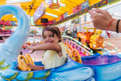 Lovely girl smiling at an amusement park, little train