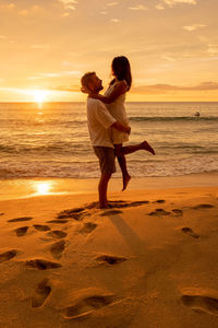 Full length of couple on beach during sunset