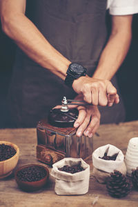 Midsection of man preparing coffee at table