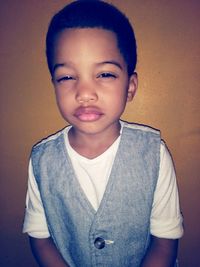 Portrait of cute boy standing against wall