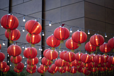 Low angle view of illuminated lanterns hanging against building