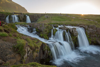 Scenic view of waterfall against sky