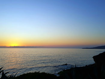 Scenic view of sea against clear sky during sunset