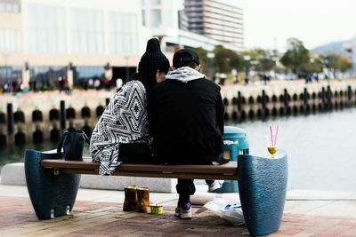 People sitting on sidewalk in city