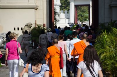 Rear view of people walking on street in city