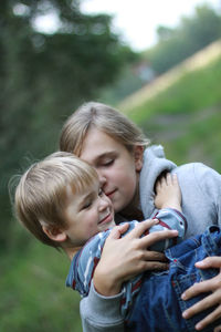 Sister carrying innocent brother