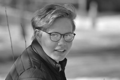 Side view portrait of teenage boy wearing eyeglasses outdoors