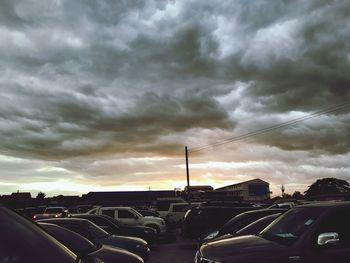 Cars on city against sky during sunset