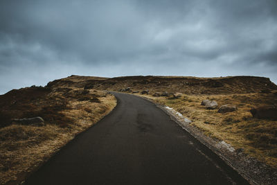 Road leading towards mountain against sky