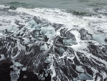 Aerial view of sea waves splashing on rocks