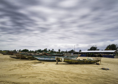 Boats moored on beach against sky