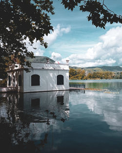 Building by lake against sky