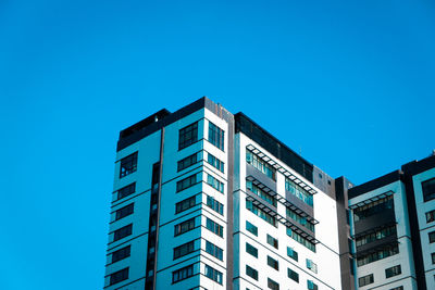 Low angle view of modern building against clear blue sky