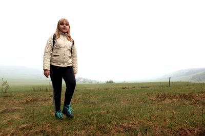 Full length of young woman standing on field