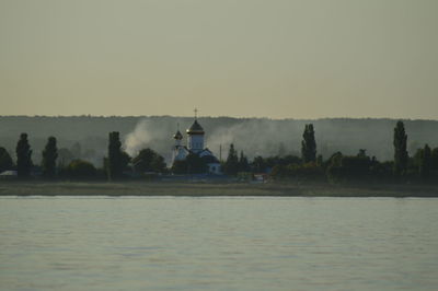 Scenic view of lake by building against clear sky