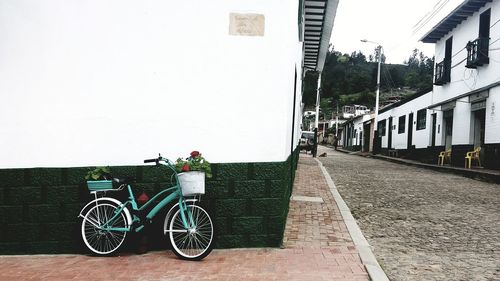 Bicycle parked on street by building