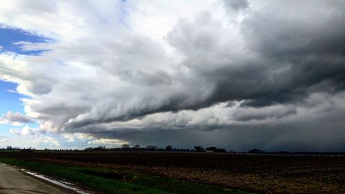 Scenic view of field against cloudy sky