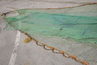 High angle view of green fishing net at harbor