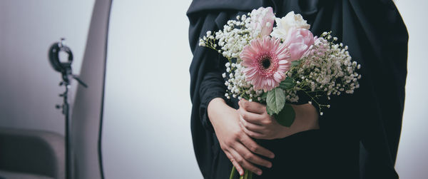 Midsection of woman holding flower bouquet